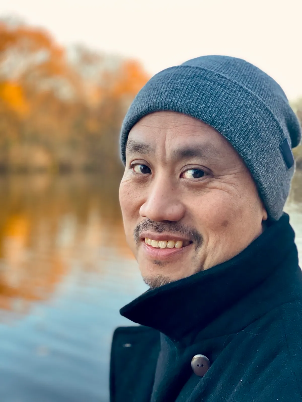 Portrait de l’auteur, au bord d’un plan d’eau en automne.